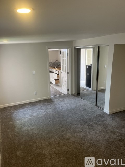 A room with a carpeted floor and a doorway leading to another room.