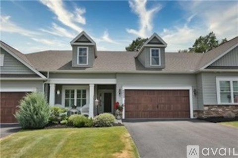 A house with a brown garage door and a stone wall.
