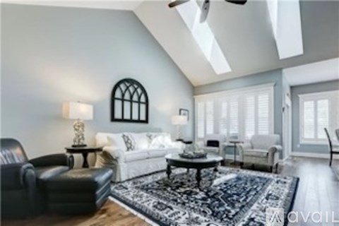 A living room with a black leather chair and a patterned rug.