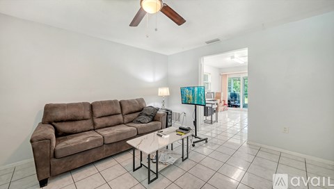 A living room with a brown couch and a white coffee table.