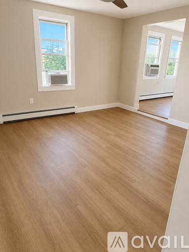 A room with wooden flooring and a window.