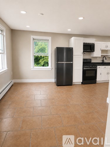 A kitchen with tile flooring and a window.