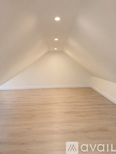 A room with wooden flooring and white walls.