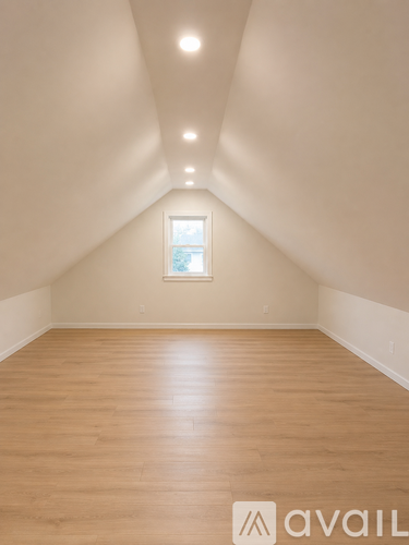 A room with wooden floors and a window in the middle of the room.
