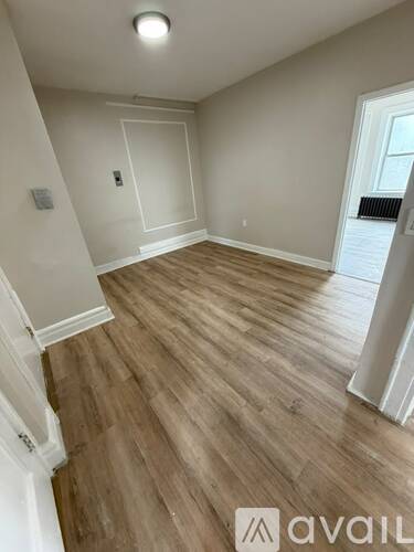 A room with wooden flooring and white walls.