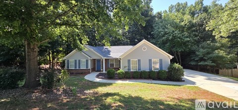 A house with a front yard and trees around it.