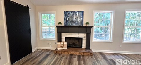 A living room with a fireplace and a painting above it.