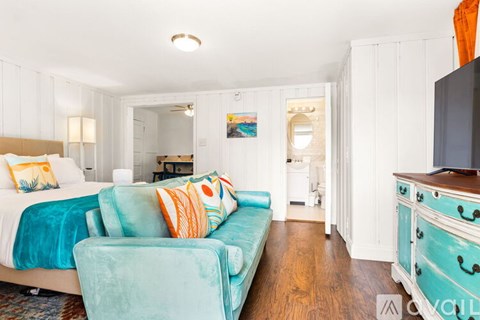 A bedroom with a bed, a couch, and a dresser.