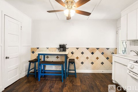 A kitchen with a table and chairs and a ceiling fan.