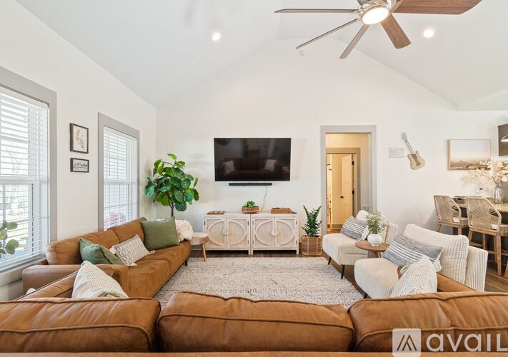A living room with a brown leather couch and a white sofa.