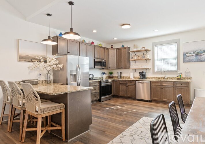 A kitchen with a table and chairs and a refrigerator.