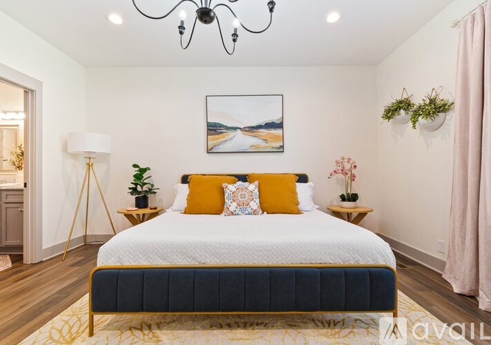 A bedroom with a large bed and a chandelier.