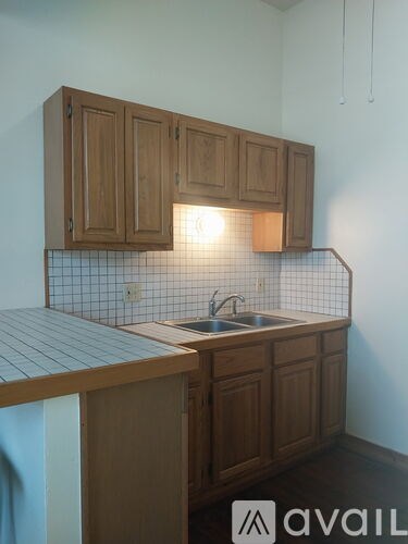 A kitchen with wooden cabinets and a tiled backsplash.