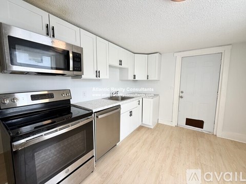 A kitchen with a stove top oven and microwave above it.