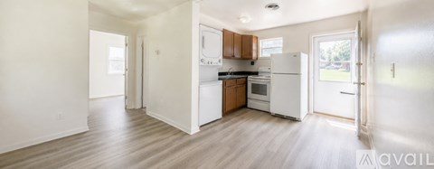 A kitchen with white appliances and wooden floors.