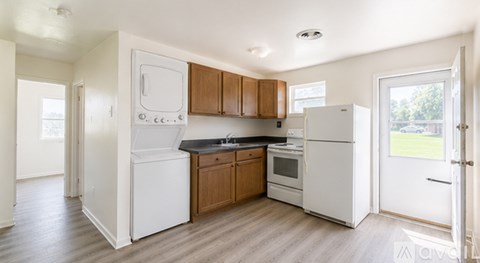 A kitchen with white appliances and wooden cabinets.