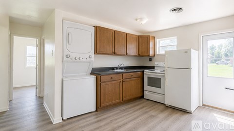 A kitchen with white appliances and wooden cabinets.