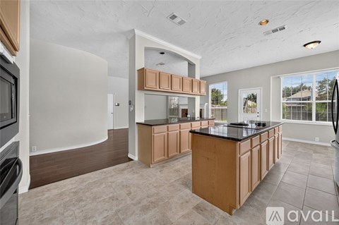 A kitchen with wooden cabinets and a black countertop.