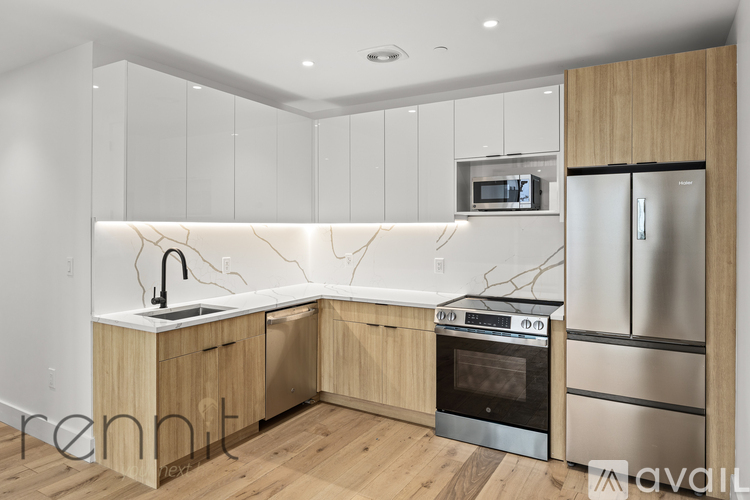 A kitchen with wooden cabinets and a marble backsplash.