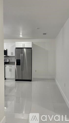 A kitchen with a refrigerator and cabinets.