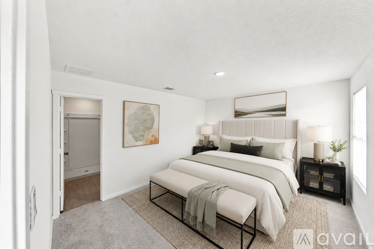 A bedroom with a large bed and a bench in front of it.