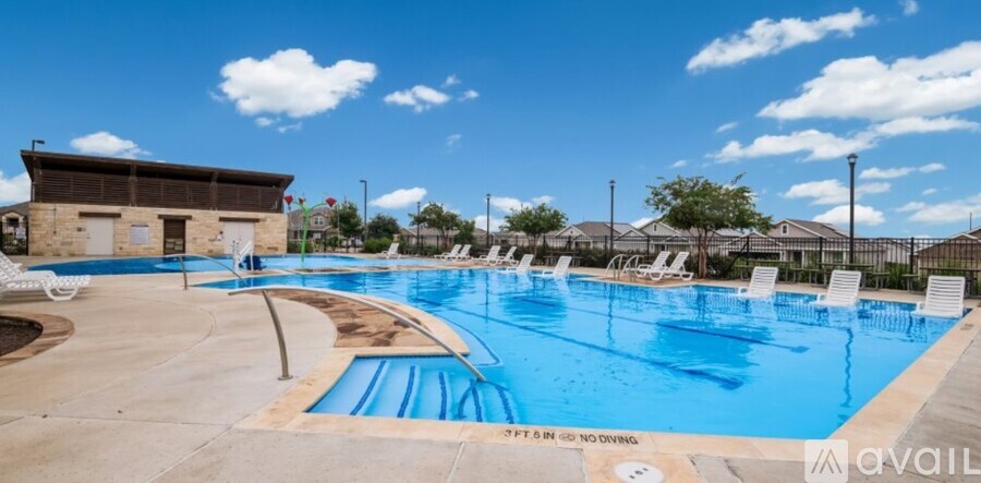 A large outdoor swimming pool with a slide and loungers.