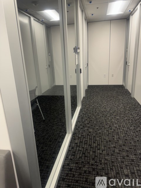 A hallway with a carpeted floor and white walls.