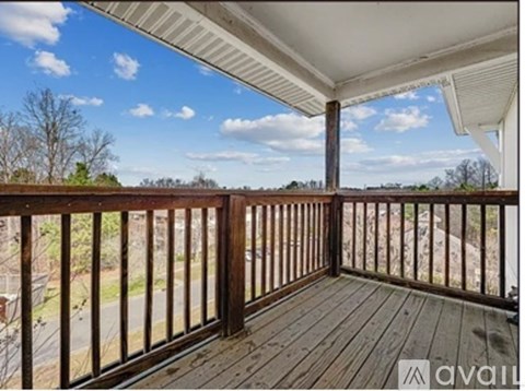 A balcony with a view of a road and trees.