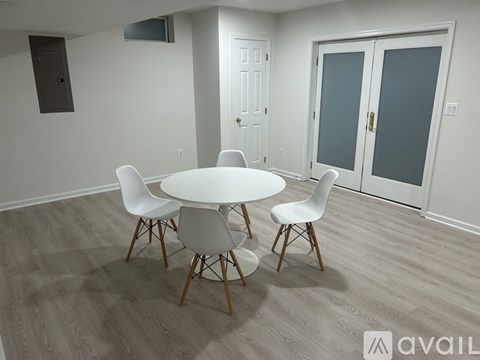 A white table surrounded by four chairs in a room.