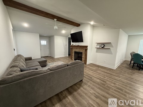 A living room with a grey couch and a fireplace.