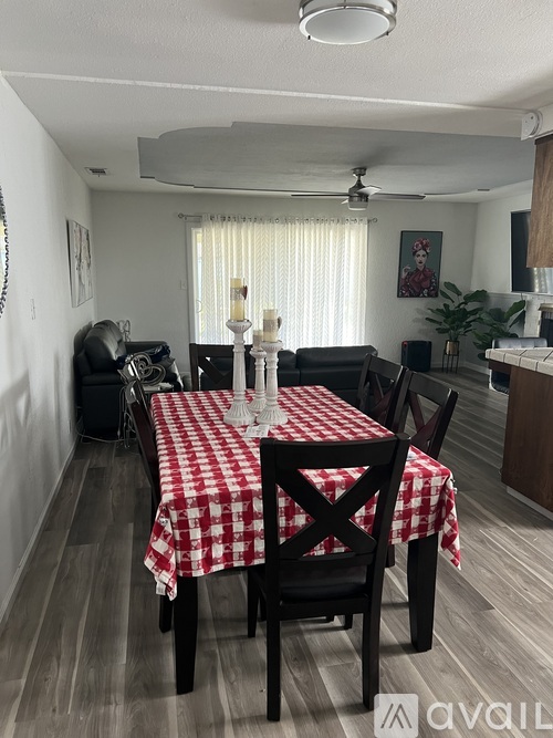 A dining room with a checkered tablecloth and chairs.