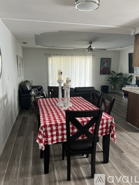 A dining room with a checkered tablecloth and chairs.