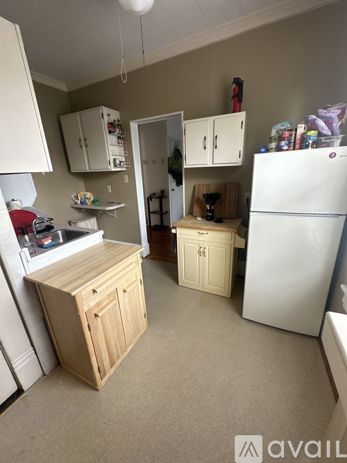 A kitchen with a white refrigerator, wooden cabinets, and a white stove top.