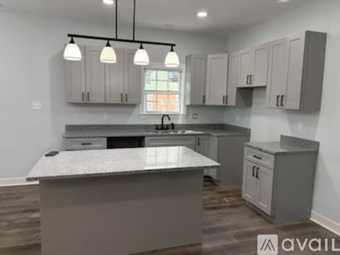 A kitchen with a large island in the middle and cabinets above it.