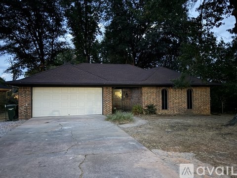 A house with a garage and a driveway in front of it.
