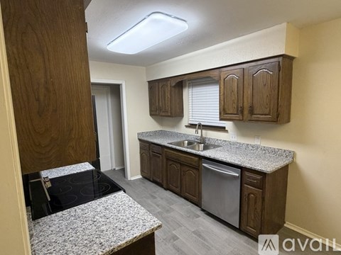 A kitchen with wooden cabinets and granite countertops.