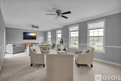 A living room with a beige sofa set and a painting on the wall.