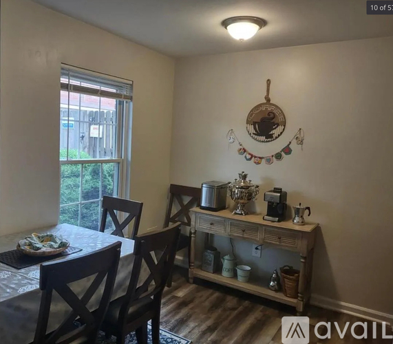 A dining room with a table set for two and a window letting in light.