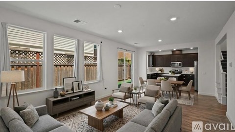 A modern living room with a grey sofa set and a wooden coffee table.