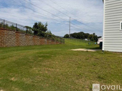 A backyard with a fence and a house.