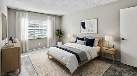 A bedroom with a large bed, a nightstand, and a window with curtains.