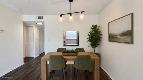 A dining room with a wooden table and chairs.