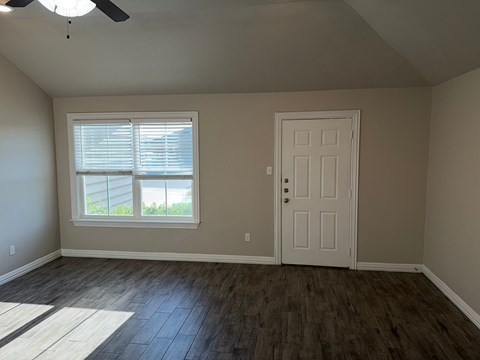 A room with a white door and a window with blinds.