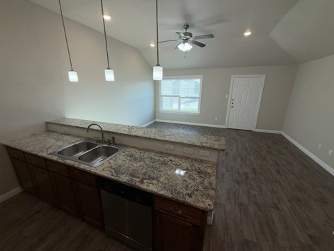 A kitchen with granite countertops and a ceiling fan.