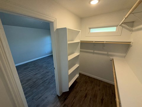 A small room with a window and a shelf.