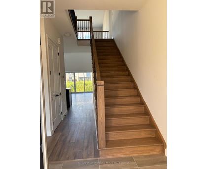 A wooden staircase with a skylight above it.