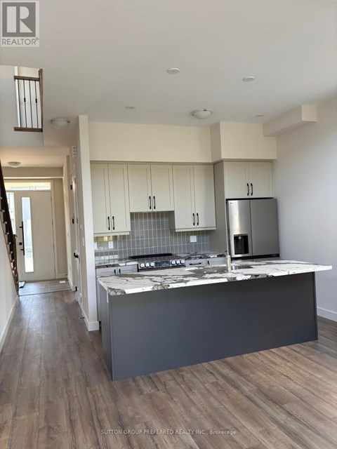 A modern kitchen with a large island and stainless steel appliances.