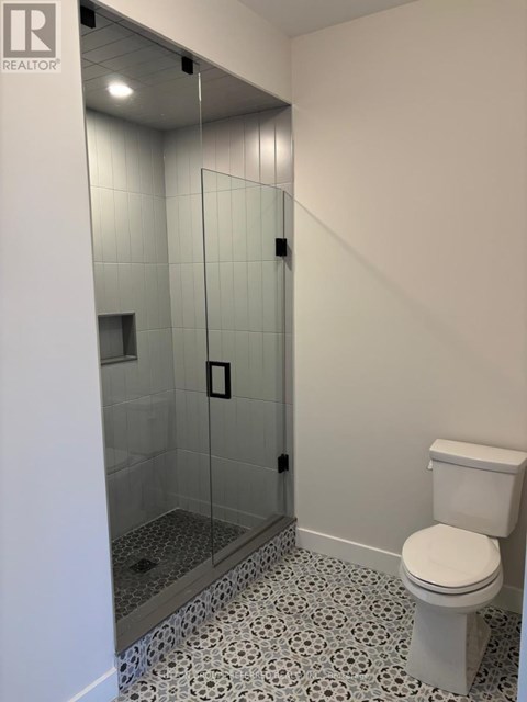 A white toilet in a bathroom with a glass shower stall.