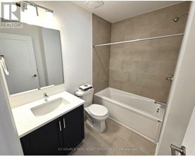 A bathroom with a sink, toilet, and bathtub.