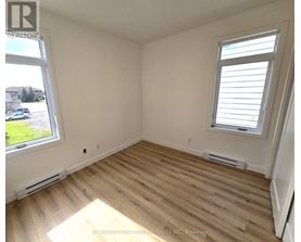 A room with wooden flooring and a window with blinds.